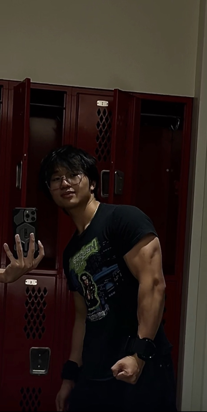 Jin taking a mirror selfie in a locker room
